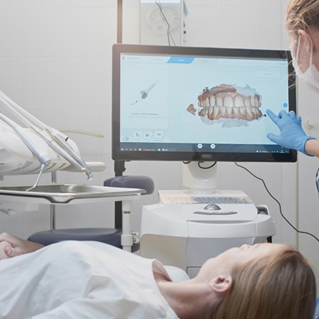 a dentist showing a patient a scan of their teeth