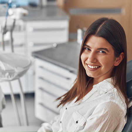 a smiling woman sitting in a dental chair