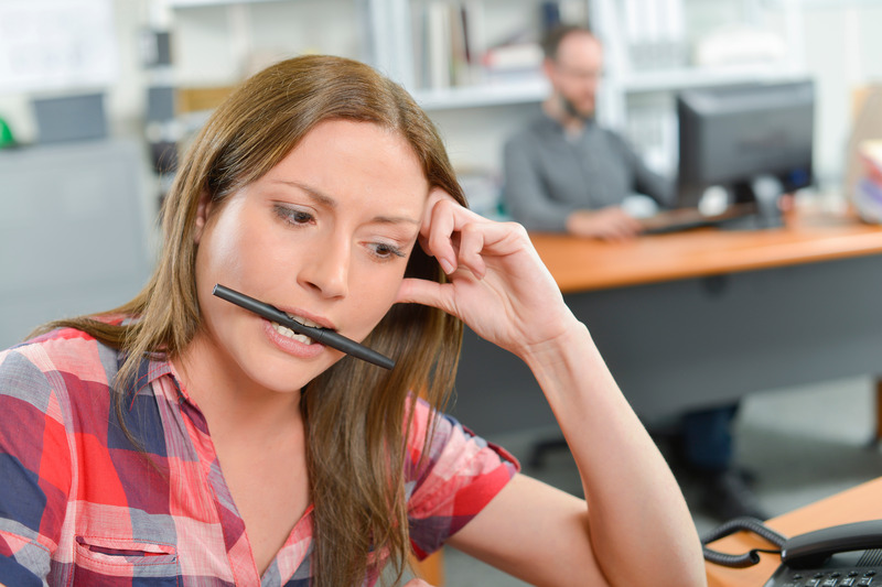 Patient with TMJ disorder chewing on a pen